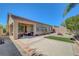 Wide view of backyard with a covered patio, seating, fire pit, mature trees, and lush greenery at 2779 Kindeace Ave, Henderson, NV 89044