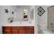 Bathroom featuring cherry wood cabinets, white marble countertop, and decorative mirror at 2779 Kindeace Ave, Henderson, NV 89044