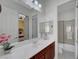Bright bathroom with wood cabinets, white countertops, dual mirrors, and shower at 2779 Kindeace Ave, Henderson, NV 89044