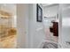 Hallway leading to a bathroom with a glass shower, tub and a living room area with cozy seating at 2779 Kindeace Ave, Henderson, NV 89044