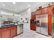 Open-concept kitchen with stainless steel appliances, dark wood cabinets, and seamless transition to the living room at 2779 Kindeace Ave, Henderson, NV 89044