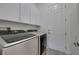 Bright laundry room featuring white cabinets, modern washer and dryer, and a convenient doorway at 2779 Kindeace Ave, Henderson, NV 89044