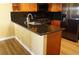 Eat-in kitchen features wood cabinets, stainless steel fridge, black granite counters and breakfast bar at 2851 S Valley View Blvd # 1134, Las Vegas, NV 89102