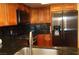 Well-lit kitchen features wood cabinets, stainless steel fridge, black granite counters and stove at 2851 S Valley View Blvd # 1134, Las Vegas, NV 89102