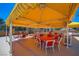 Spacious outdoor dining area with multiple tables and chairs under a vibrant yellow canopy, perfect for gatherings at 3111 Bel Air Dr # 201, Las Vegas, NV 89109