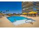Stunning swimming pool with steps, palm trees, yellow canopies, and clear blue water, ideal for relaxation and recreation at 3111 Bel Air Dr # 201, Las Vegas, NV 89109
