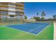Well-maintained tennis court with vibrant blue surface, surrounded by lush green grass and tall palm trees, perfect for sports enthusiasts at 3111 Bel Air Dr # 201, Las Vegas, NV 89109