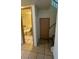 Hallway with tile flooring and a door leading to a bathroom with a bathtub and toilet, offering convenience and functionality at 3412 Mercury St # I, North Las Vegas, NV 89030