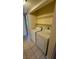 Laundry area includes side-by-side washer and dryer plus shelving for storage at 3412 Mercury St # I, North Las Vegas, NV 89030