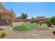 This landscaped backyard features an artificial lawn, mature shrubs, and a retaining wall at 3609 Kingfishers Catch Ave, North Las Vegas, NV 89084