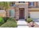 Inviting two-story home featuring stone accents and mature landscaping leading to the front door at 3609 Kingfishers Catch Ave, North Las Vegas, NV 89084