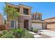 Two-story home featuring stone accents, a two-car garage, and mature landscaping at 3609 Kingfishers Catch Ave, North Las Vegas, NV 89084