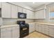 Close-up of kitchen featuring neutral cabinets and black appliances at 3609 Kingfishers Catch Ave, North Las Vegas, NV 89084
