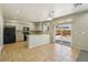 Bright eat-in kitchen with tan cabinets, black appliances, and sliding glass doors to the backyard at 3609 Kingfishers Catch Ave, North Las Vegas, NV 89084