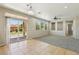 Open living room boasts tile and carpet flooring, sliding glass doors, and large windows for ample natural light at 3609 Kingfishers Catch Ave, North Las Vegas, NV 89084