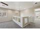 Bright loft features neutral walls and carpet flooring, two windows, and glass railing at 3609 Kingfishers Catch Ave, North Las Vegas, NV 89084
