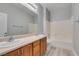 Bathroom featuring dual sinks, wood cabinets, a bathtub, a shower and a large mirror at 3941 Copper Stone Ct, North Las Vegas, NV 89032