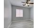 Well-lit bedroom with modern gray walls, wood-look floors, ceiling fan and a large window at 3941 Copper Stone Ct, North Las Vegas, NV 89032
