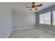 Bright bedroom with modern gray walls, wood-look floors, ceiling fan and dual windows at 3941 Copper Stone Ct, North Las Vegas, NV 89032