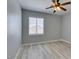Bedroom featuring modern gray walls, wood-look floors, ceiling fan and a window with blinds at 3941 Copper Stone Ct, North Las Vegas, NV 89032