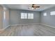 A spacious bonus room featuring neutral gray walls, wood-look floors, three windows and a ceiling fan at 3941 Copper Stone Ct, North Las Vegas, NV 89032
