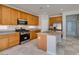 Well-lit kitchen featuring wooden cabinets, stainless steel appliances, and a large island with a granite countertop at 3941 Copper Stone Ct, North Las Vegas, NV 89032