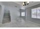 Bright living room featuring tile flooring, natural light from windows, and staircase access at 3941 Copper Stone Ct, North Las Vegas, NV 89032