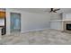 Open living room with tile floors, leading into kitchen and featuring a stone fireplace at 3941 Copper Stone Ct, North Las Vegas, NV 89032