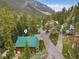 Aerial view of a charming log cabin with a green roof nestled among trees in a mountain community at 401 Alpine Way, Mount Charleston, NV 89124