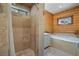 Modern bathroom featuring tiled walls and flooring, with a walk-in shower and separate soaking tub at 401 Alpine Way, Mount Charleston, NV 89124