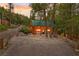 Quaint log cabin with green roof surrounded by mature trees and lush greenery on a spacious lot at 401 Alpine Way, Mount Charleston, NV 89124