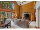 Open-concept living area featuring log walls, a wood-burning stove, and large windows overlooking the forest at 401 Alpine Way, Mount Charleston, NV 89124