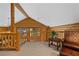 Carpeted loft space with log walls, a beamed ceiling, and railing overlooking the downstairs at 401 Alpine Way, Mount Charleston, NV 89124