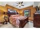 Bedroom with log walls, neutral carpeting, a dark wood bedframe and outside view at 401 Alpine Way, Mount Charleston, NV 89124