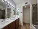 Bathroom featuring double sinks, wood floors, updated fixtures, and walk-in shower at 453 Las Casitas Way, Las Vegas, NV 89121