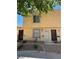 Townhouse exterior featuring tan stucco, security doors, and landscaped front yard with decorative rock at 453 Las Casitas Way, Las Vegas, NV 89121