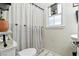 Compact bathroom featuring a toilet, tub with curtain, and small window at 517 5Th St, Boulder City, NV 89005