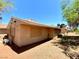 Exterior view of a tan home with desert landscaping and a shaded yard with mature trees at 5215 Gray Ln, Las Vegas, NV 89119