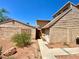 Exterior view of a home with tan brick and siding, showcasing the walkway and desert landscaping at 5215 Gray Ln, Las Vegas, NV 89119