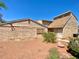 Exterior view of a tan home with brick and siding, emphasizing its desert landscaping and backyard at 5215 Gray Ln, Las Vegas, NV 89119