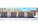 View of multiple garages with tan doors and textured walls under a blue sky at 5215 Gray Ln, Las Vegas, NV 89119