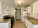 A bright kitchen features white cabinets, tile countertops, and essential appliances for cooking at 5215 Gray Ln, Las Vegas, NV 89119