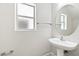 Well-lit bathroom featuring a modern sink, round mirror, towel rack, and a bright window at 5824 Gemstone Peak St, North Las Vegas, NV 89031