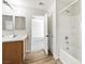 Bathroom featuring a single vanity, large mirror, and shower-tub combo with bright lighting at 5824 Gemstone Peak St, North Las Vegas, NV 89031