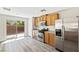 Bright kitchen with stainless steel appliances, oak cabinets and sliding door to backyard at 5824 Gemstone Peak St, North Las Vegas, NV 89031