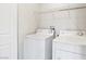 Practical laundry area equipped with a washer, dryer, and overhead storage shelving at 5824 Gemstone Peak St, North Las Vegas, NV 89031