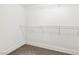 Walk-in closet featuring carpet flooring and white shelving at 5824 Gemstone Peak St, North Las Vegas, NV 89031