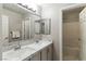 Bright bathroom featuring double sinks, marble countertops, and modern tile accents around a large mirror at 620 Painted Cloud Pl, Las Vegas, NV 89144
