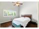 Cozy bedroom with a ceiling fan, wood floors, and a window with plantation shutters at 620 Painted Cloud Pl, Las Vegas, NV 89144