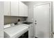 Efficient laundry room with white cabinets, modern washer and dryer units, and ample storage at 620 Painted Cloud Pl, Las Vegas, NV 89144